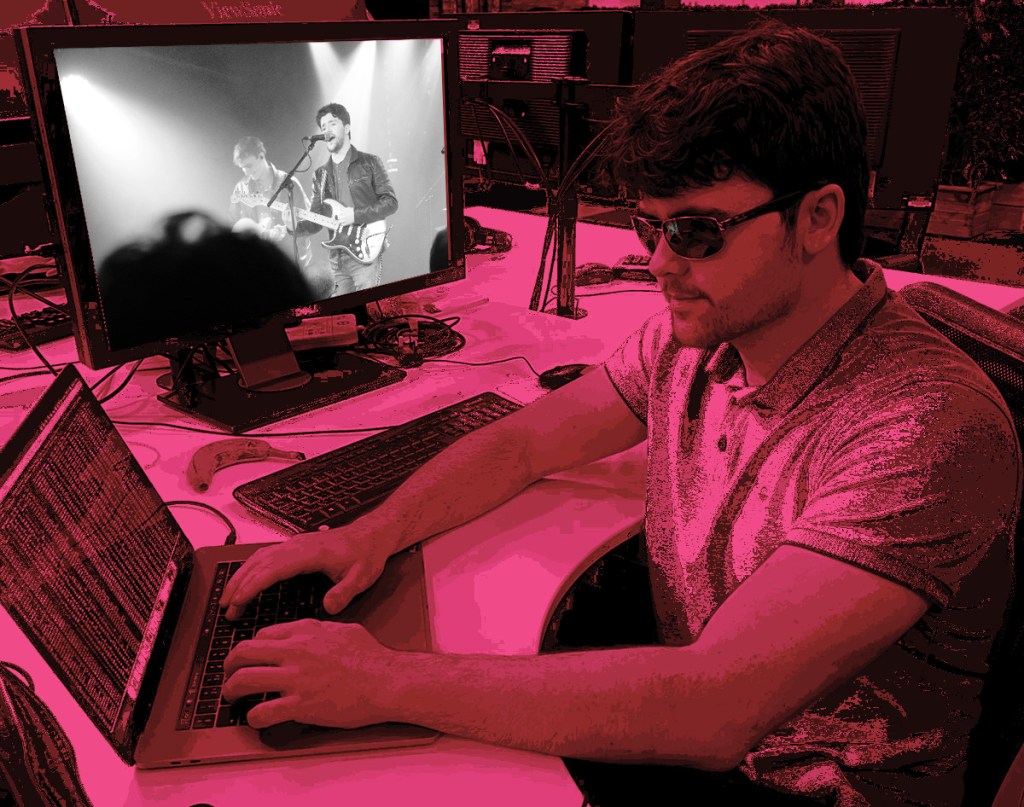 Edited Photo of James Henry at a laptop, photo Michael Henry on the screen beside